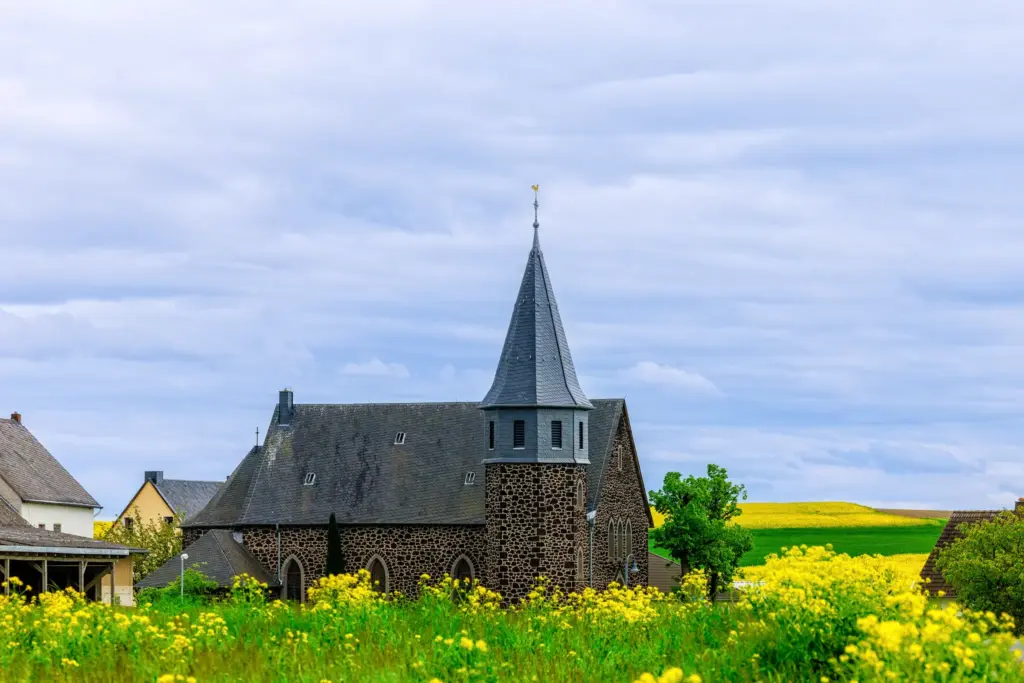 Kirche Christ König in Kaan mit achteckigem Glockenturm und Hahn auf dem Dach